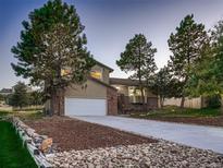 Charming two-story home featuring a brick and siding exterior with a two-car garage and a well-manicured front yard at 8916 Sunridge Hollow Rd, Parker, CO 80134