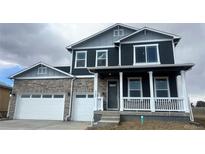 Charming two-story home featuring a stone facade, covered porch, and a two-car garage at 1102 Ridgefield Dr, Berthoud, CO 80513