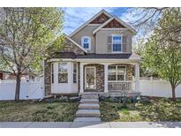 Charming two-story home boasts a welcoming front porch and beautifully maintained landscaping at 736 Trenton St, Denver, CO 80230