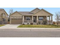 Charming home with a stone facade, covered porch, and well-manicured lawn at 6302 E 135Th Ave, Thornton, CO 80602