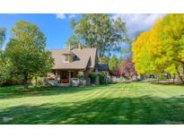Charming home featuring a lush green lawn, mature trees, and unique architectural details at 3737 26Th St, Boulder, CO 80304
