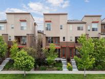 Attractive townhomes with private balconies, well-maintained lawns, and mature trees at 8336 E 35Th Ave, Denver, CO 80238