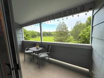 Cozy balcony with string lights and seating overlooking a green space at 4676 White Rock Cir # 12, Boulder, CO 80301