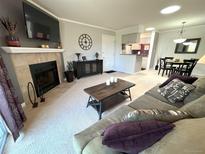 Inviting living room featuring a fireplace, mounted TV, neutral carpet, and comfortable seating at 4676 White Rock Cir # 12, Boulder, CO 80301
