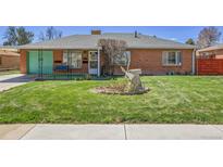 Charming home with a lush green lawn and decorative windmill at 891 Ursula St, Aurora, CO 80011