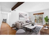 Bright living room with a stylish sofa, modern decor, and sliding glass doors to a balcony at 16359 W 10Th Ave # X6, Golden, CO 80401