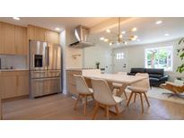 Modern kitchen with stainless steel appliances, a sleek island, and an open dining area perfect for gatherings at 2441 W 55Th Ave, Denver, CO 80221