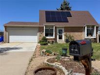 Charming brick home featuring solar panels, a well-manicured lawn, and a mailbox with the house number at 4383 S Eagle Cir, Aurora, CO 80015