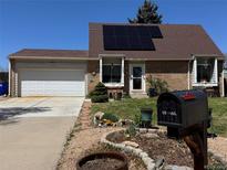 Charming front exterior view of home, landscaped front yard, and solar panels on the roof at 4383 S Eagle Cir, Aurora, CO 80015