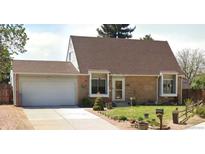 Charming single-story home with a well-maintained lawn and a classic brick facade and an attached one car garage at 4383 S Eagle Cir, Aurora, CO 80015