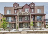 Beautiful townhome featuring a stone facade, balconies, and a modern architectural design at 9662 Browns Peak Cir, Littleton, CO 80125