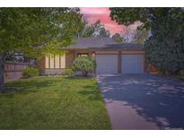 Charming single-story home with a well-manicured lawn and a two-car garage at 8144 W 81St Dr, Arvada, CO 80005