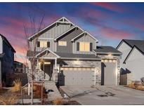 Beautiful two-story home with stone accents, three car garage, gray siding and a landscaped front yard at 21901 E 42Nd Pl, Aurora, CO 80019