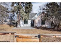 Charming single-story home with a mix of white siding and weathered brick accents, complemented by mature trees at 9393 W 14Th Ave, Lakewood, CO 80215