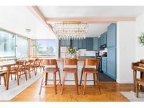 Bright kitchen featuring blue cabinets, wood countertops, a chandelier, and seating at the kitchen island at 800 Washington St # 302, Denver, CO 80203
