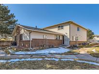 Two-story home featuring a brick foundation and light siding under a blue sky at 3354 S Flower St # 14, Lakewood, CO 80227