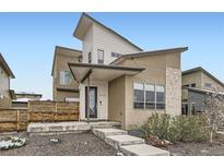 Stunning modern home featuring unique architectural details and a covered front porch with landscaped yard at 9715 Taylor River Cir, Littleton, CO 80125