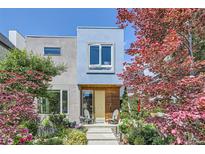 Modern home featuring a colorful front yard with lush gardens and a welcoming front porch with chairs at 3931 Utica St, Denver, CO 80212