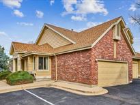 Tan brick and wood exterior of the home with a two-car garage at 2132 S Scranton Way, Aurora, CO 80014