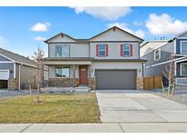 Two-story house with gray siding, red accents, and a two-car garage at 9902 Cathay St, Commerce City, CO 80022