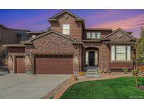 Beautiful two-story home with a brick facade, attached garage, and well-manicured lawn, creating an inviting curb appeal at 3745 Spanish Oaks Trl, Castle Rock, CO 80108