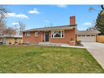 Charming brick home featuring a lush front lawn and an attached garage at 6620 S Foresthill St, Littleton, CO 80120