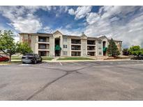 Well-maintained apartment building featuring multiple balconies and ample parking, set against a partly cloudy sky at 12183 W Cross Dr # 202, Littleton, CO 80127