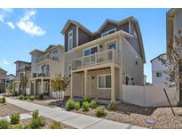 Charming multi-level townhome with balconies, neutral siding, and landscaped front yard at 18233 E 51St Ave, Denver, CO 80249
