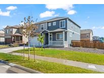 Charming two-story home with a well-maintained lawn and inviting front porch at 902 William Way, Brighton, CO 80603