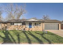 Charming ranch-style home with brick facade, manicured lawn, and a blue front door at 3094 S Hobart Way, Denver, CO 80227