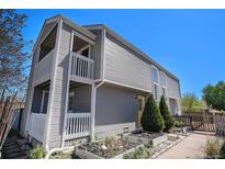 Stylish two-story home with dual balconies, gray siding, garden boxes, and a bright yellow door at 1403 Valentia St, Denver, CO 80220