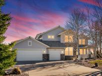 Charming two-story home with stone accents and a well-manicured lawn at sunset at 49220 W Antelope Dr, Bennett, CO 80102
