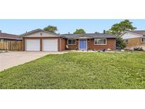 Charming brick home with a well-maintained lawn and a welcoming blue front door at 865 S 8Th Ave, Brighton, CO 80601