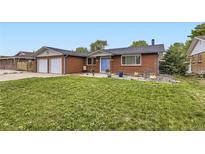 Charming red brick home with a well-maintained front yard and blue door at 865 S 8Th Ave, Brighton, CO 80601
