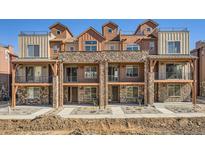 New townhomes featuring stone accents, balconies and rooftop decks at 9654 Browns Peak Cir, Littleton, CO 80125