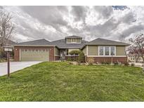 Brick and shingle ranch home with attached two-car garage and landscaped lawn at 7851 S Quatar Ct, Aurora, CO 80016