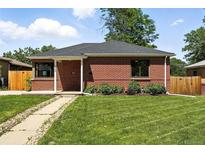 Charming brick home with a well-maintained lawn and classic architectural details at 2955 Poplar St, Denver, CO 80207