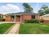 Charming brick home with a well-manicured front yard and a stone walkway leading to the entrance at 2955 Poplar St, Denver, CO 80207