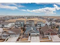 Expansive aerial view of a new construction residential neighborhood under a bright blue partially cloudy sky at 8234 S Vandriver Way, Aurora, CO 80016