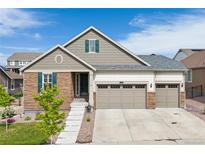 Charming single-Gathering home with a three-car garage, stone accents, and manicured front yard at 8234 S Vandriver Way, Aurora, CO 80016
