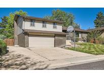 Two-story home with a brick and vinyl exterior and a spacious two-car garage and driveway at 7294 S Syracuse St, Centennial, CO 80112