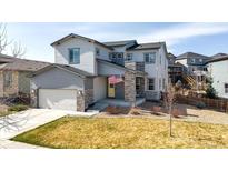 Charming two-story home with gray siding, stone accents, a two-car garage, and a welcoming front yard at 117 Nova Ct, Erie, CO 80516