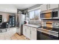 Well-lit kitchen featuring stainless steel appliances, ample cabinet space, and granite countertops at 17185 E Florida Pl, Aurora, CO 80017