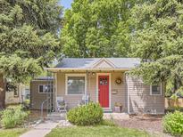 Charming single-story home featuring a well-kept lawn, front porch and vibrant red door at 3265 S Ogden St, Englewood, CO 80113