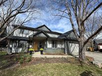 Charming two-story home featuring a well-maintained lawn, complemented by blooming daffodils, and a welcoming front porch at 7909 Fairfax Ct, Niwot, CO 80503