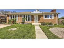 Charming brick home with a well-manicured lawn, inviting entrance, and lovely curb appeal at 10712 Larson Dr, Northglenn, CO 80233