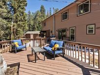 Relax on the spacious deck with cozy seating and enjoy serene outdoor living among the trees at 28268 Shadow Mountain Dr, Conifer, CO 80433