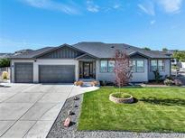 Charming single-story home featuring a well-maintained front yard and a spacious three-car garage at 525 Remington Dr, Hudson, CO 80642
