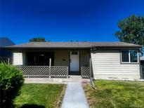 Charming single-story home with a cozy front porch and well-maintained lawn at 235 S Stuart St, Denver, CO 80219