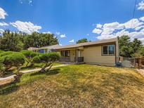 Charming single-story home with a well-maintained lawn and mature landscaping at 235 S Stuart St, Denver, CO 80219
